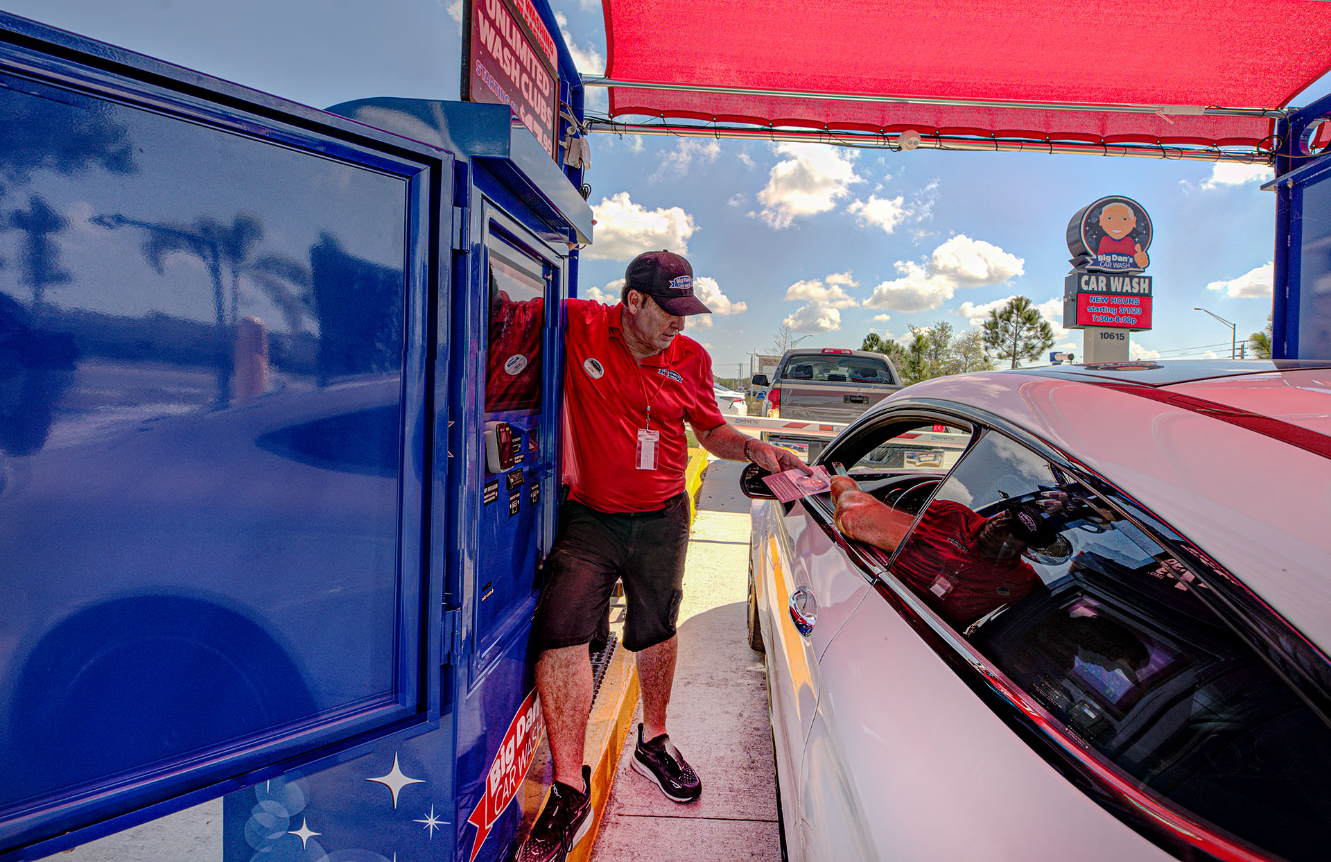 Attendant assisting a customer in their car